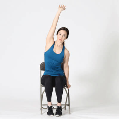 Female sitting in chair demonstrating workplace stretching technique.