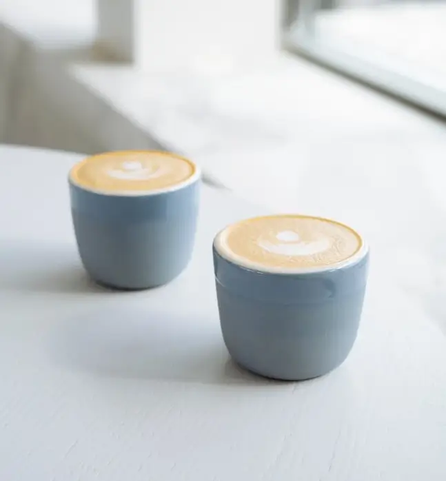 two coffee cups near window,