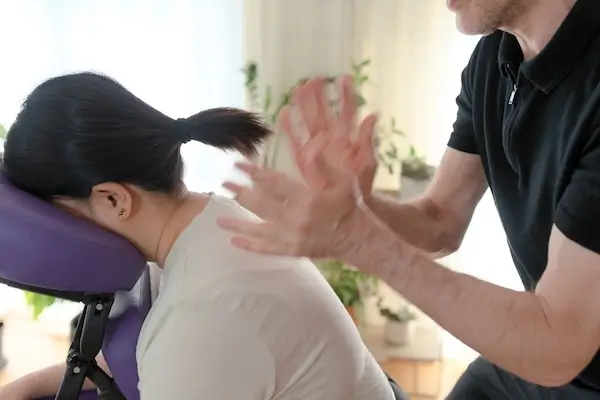 Therapist fast hands tapoment technique on client's shoulders.